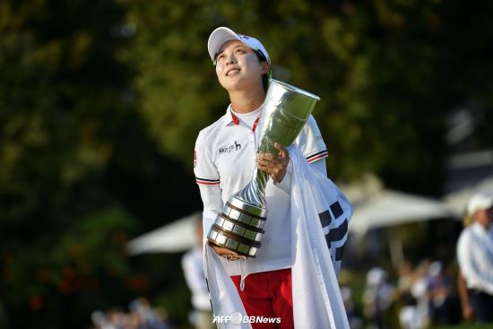 15일(한국시간) 끝난 미국LPGA 투어 에비앙 챔피언십에서 초청선수로 우승한 김효주가 태극기를 두른 채 우승컵을 들고 애국가를 경청하고  있다. AFPBBNews=News1