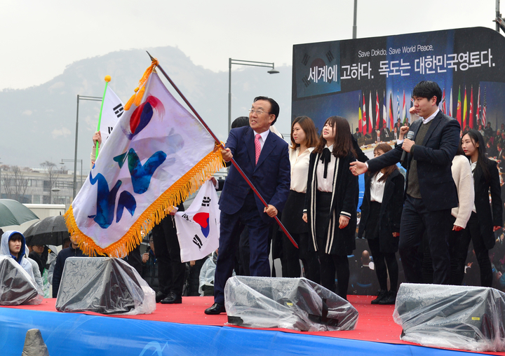 김관용 도지사가 지난 2월 서울 광화문 광장에서 열린 ‘대한민국 독도 수호 범국민 다짐대회’에서 독도기를 흔들며 독도 수호 의지를 표명하고 있다. 경상북도 제공.